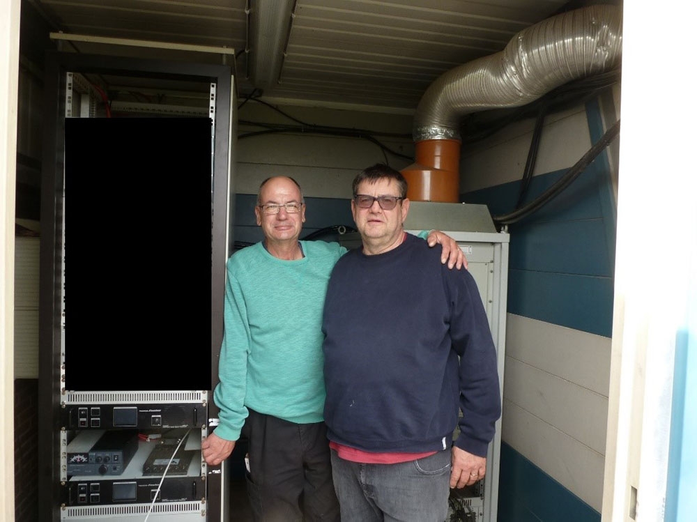 Paul ON6DP (à droite) et Jean-François ON4IJ (à gauche) à côté de l’armoire électronique lors de la remise en service du répéteur ON0LG VHF